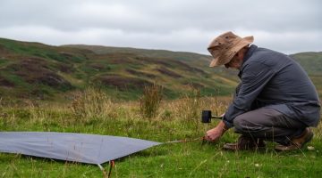 pegging-down-a-ground-sheet-or-tent-footprint-in-preparation-for-camping